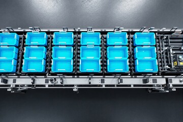 Poster - Automated conveyor system with blue storage bins in an industrial setting.