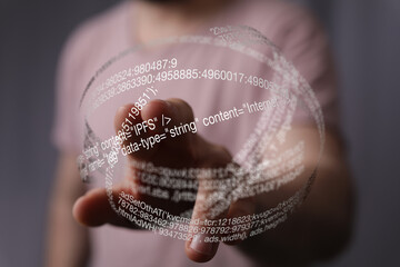 Fototapete - A hand interacts with a futuristic holographic display showing code and data.