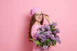 © New Africa - Portrait of smiling teenage girl with lilac flowers on pink background