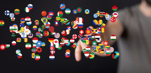 Fototapete - Hand interacting with a digital display of world flags, symbolizing global connection and communication.