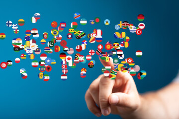 Aufkleber - A hand interacts with a digital display of world flags, symbolizing global connection and communication.