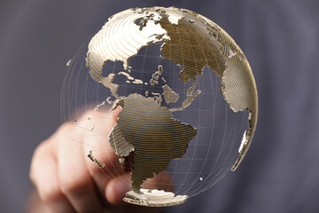 Leinwandbilder - High-quality stock photo of a hand interacting with a transparent 3D model of Earth, showcasing global connectivity.