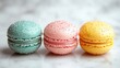 © Junaed Ahamed Sakib - A row of three colorful macarons with sprinkles on a light surface
