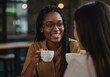 © Laki - Two women drinking coffee and talking in a cafe, smiling