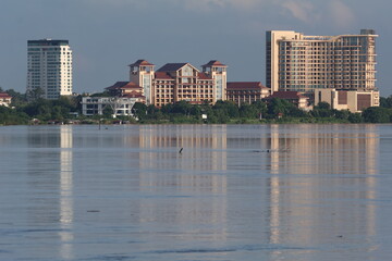 Wall Mural - building reflect on the mekong river, showcasing urban architecture and towering skyscrapers, vienti