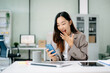 © Nuttapong punna - Asian businesswoman cheering with phone at desk, celebrating work success. and the goal was achieved, happy