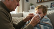 © Irma - Elderly man caring for boy with tissue while sitting on sofa at home