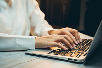 Poster - Business concept of working, Close-Up of Hands Typing on Laptop Keyboard in Cozy Workspace with Warm Light and Minimalist Decor