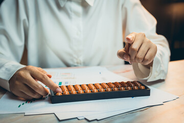 Poster - Business calculation concept. Business Professional Using Abacus for Calculation in Office Setting with Financial Charts and Documents