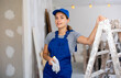 © JackF - Portrait of positive young woman construction worker in apartment.