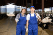 © JackF - Adult man and young boy farmers posing with tools at dairy farm