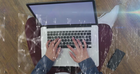 Poster - Image of network of connections against overhead view of a person using laptop