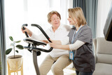 Senior woman doing exercise on bike simulator to keep her health and recovery after trauma