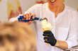 © Anastasiia - Woman in white outfit scooping white ball-shaped ice cream into a cone with a metal scoop. Bright, clean background emphasizes the dessert preparation moment.