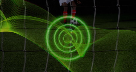 Poster - Image of spiral light trail against mid section of male soccer player taking a penalty kick