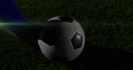 Poster - Image of light trails over football player kicking ball at stadium