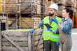 © Prostock-studio - Management, sale and storage, control of organic fruit business and industry. Millennial woman and man in helmet with tablet check order details near forklift truck, on many wooden boxes background