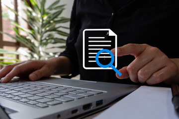 Poster - Businesswoman working on her laptop, pointing at a magnifying glass icon reviewing a document
