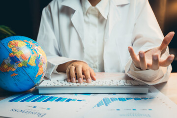 Poster - Medical concept. Person in Lab Coat Discussing Business Data Analysis with Globe and Reports on Desk in Modern Office Setting