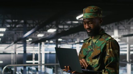 Poster - Army technician in command center server room using laptop to install and maintain IT systems. Military data center admin overseeing computer networks and information systems, camera B