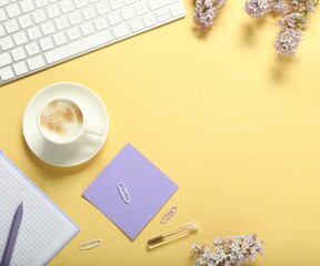 Poster - Flat lay composition with stationery, coffee and flowers on beige background. Space for text
