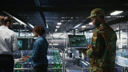Poster - Military technician in data center monitoring warfare drone telemetry on laptop dashboard. IT specialist in army server room using tactical interface on notebook to support aerial operations, camera A