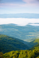 Wall Mural - mountainous countryside landscape with fog in the distant valley. mist rolling among hills in mornin