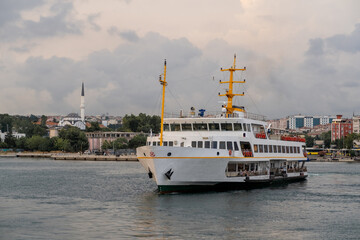 Aufkleber - Bosphorus ferry cruising past city skyline and historical buildings on a cloudy day
