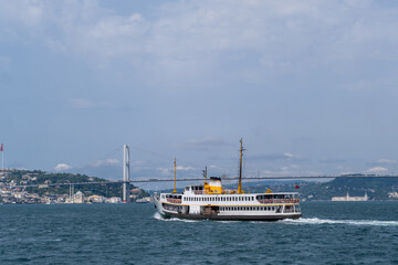 Aufkleber - Ferry navigating the Bosphorus strait under an iconic bridge with city skyline in the background