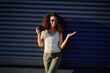 © khmelev - trendy woman with camera smiling confidently against metallic wall, wearing stylish sunglasses, embracing casual urban fashion vibe. perfect for lifestyle, photography, and creativity themes