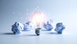 © Panarat - a white light bulb with papers crumpled at its base is placed centrally in the frame against a plain background, symbolizing innovation or ideas coming together.