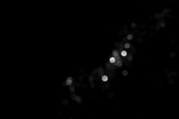 Wall Mural - white gray blurred bokeh lights on black background. glitter sparkle stars for celebrate. overlay fo