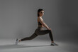 © Sandu - Fitness enthusiast performing a lunge exercise in a minimalist studio setting during a workout session