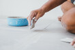 © sorapop - Hand gripping a rubber float tool while pressing grout into the spaces between ceramic floor tiles. Close-up showing seamless tile work.
