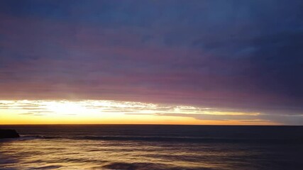 Aufkleber - Dramatic sunset over ocean waves crashing on rocks.