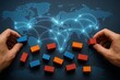 © Creative mind - Global network map with hands arranging blocks. The image depicts a connection network linking worldwide locations through blue lines.