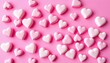 © Prasong - Delicate pink candy hearts scattered on a textured pink background, creating a sweet repeating pattern,  confection, love