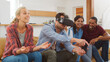 © Monkey Business - Group Of Multi Cultural Friends Playing Computer Game With Virtual Reality Headset At Home