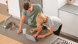 © Monkey Business - Overhead View Of Couple Looking At Laptop In Modern Kitchen