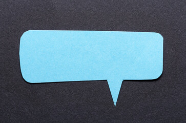 Aufkleber - Blue cut out blank paper speech bubble of rectangular shape and rounded corners with copy space for text on dark background, flat lay top view conceptual backdrop