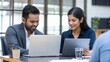 © Jo - Positive Indian Coworkers Using Laptops and Tablets in Modern Business Meeting