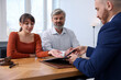© New Africa - Couple having meeting with professional notary at wooden desk indoors