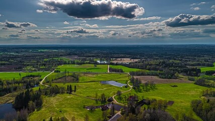 Wall Mural - timelapse aerial view of rural landscape with fields, winding roads and cloud shadows