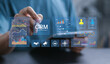 © Pakin - Customer relationship management software concept. Businessman using tablet with CRM icon on virtual screen. CRM for sales, Sales control and monitoring software with client database.