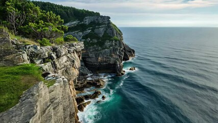 Poster - Explore stunning rocky coastline with clear blue waters and lush greenery under a bright sky in a captivating 4k stock video