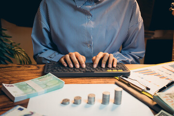 Poster - business concept. focused person working on financial analysis with cash and charts on desk at home 