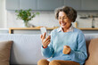 © Home-stock - Happy elderly woman using smartphone at home, making video call, consulting doctor at virtual meeting on mobile phone and smiling at screen