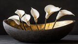Elegant white calla lilies in a dark, textured bowl.