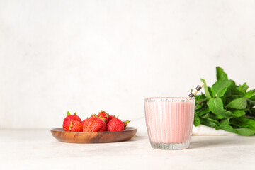 Wall Mural - Glass of tasty strawberry smoothie on light background