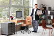 © Pixel-Shot - Young businessman working with laptop in office. National Wear Your Pajamas to Work Day